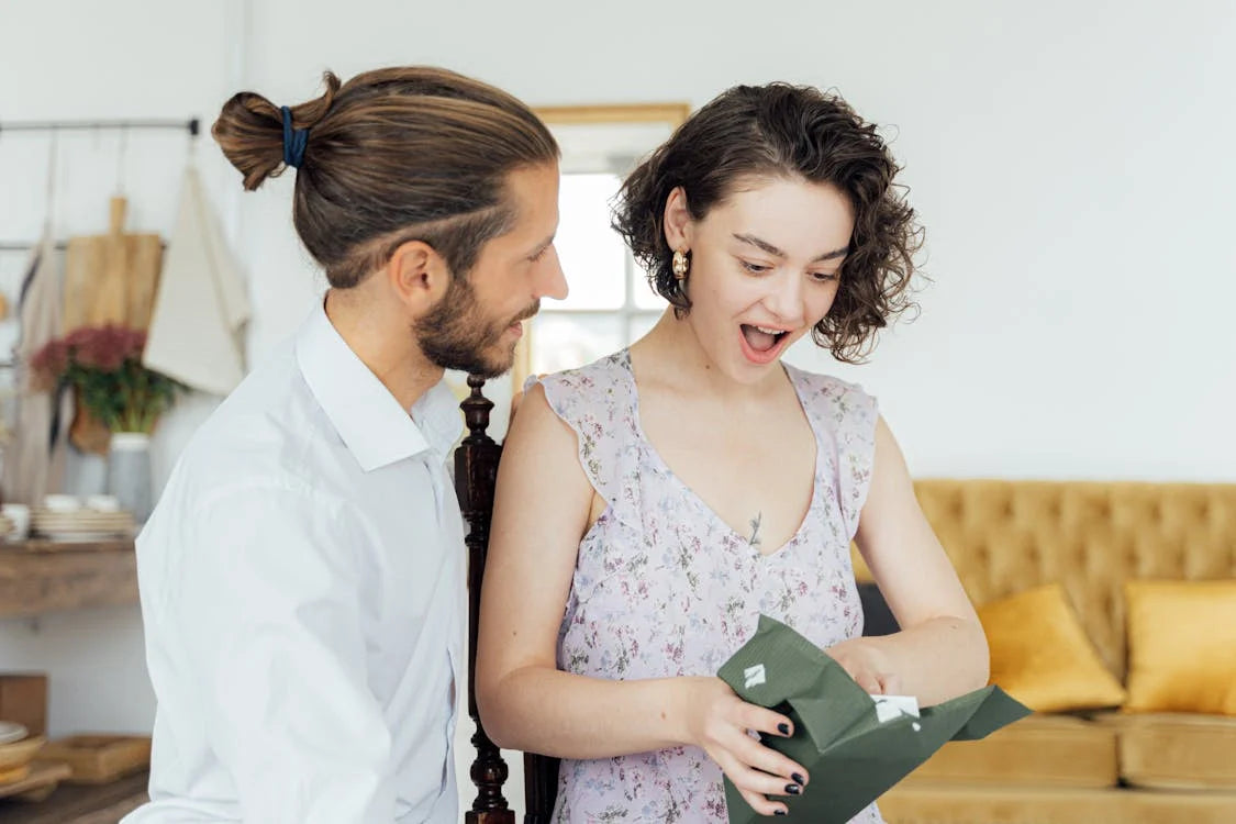 a woman opening a present which could be a deck of Plants Against Veganity